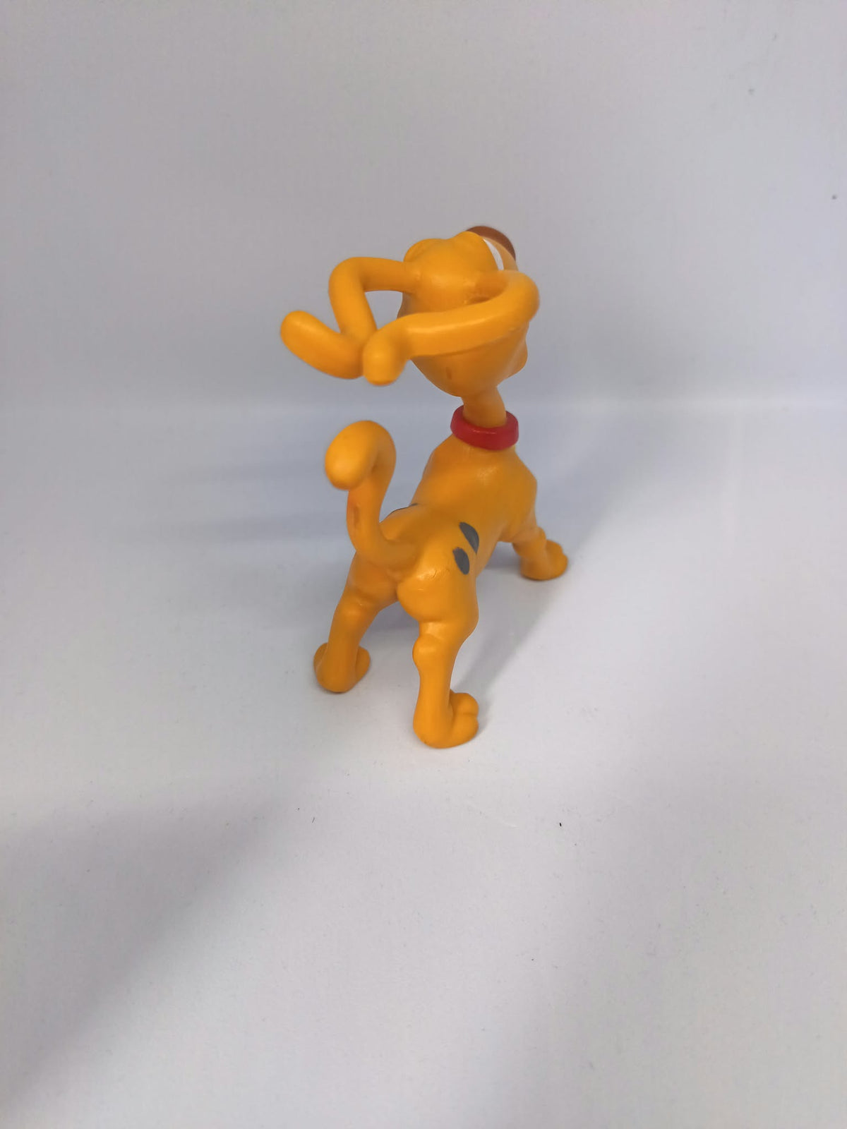 Détail du collier rouge et de la médaille jaune de la figurine Spike
