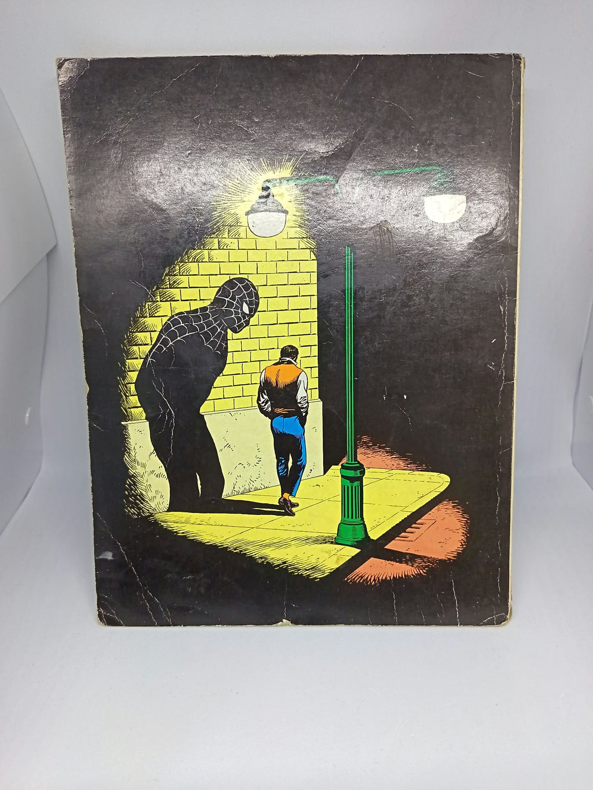 Dos du comics avec illustration de Spider-Man en costume noir sous un lampadaire